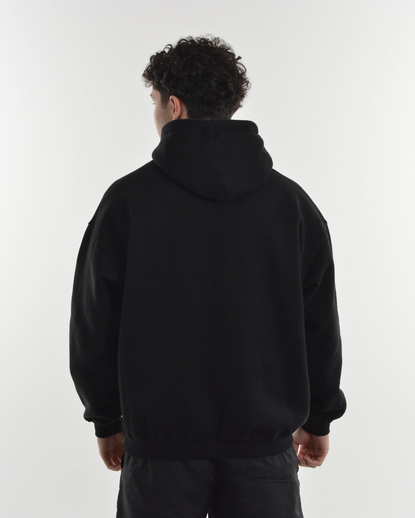 Person wearing a black hoodie from behind on a white background