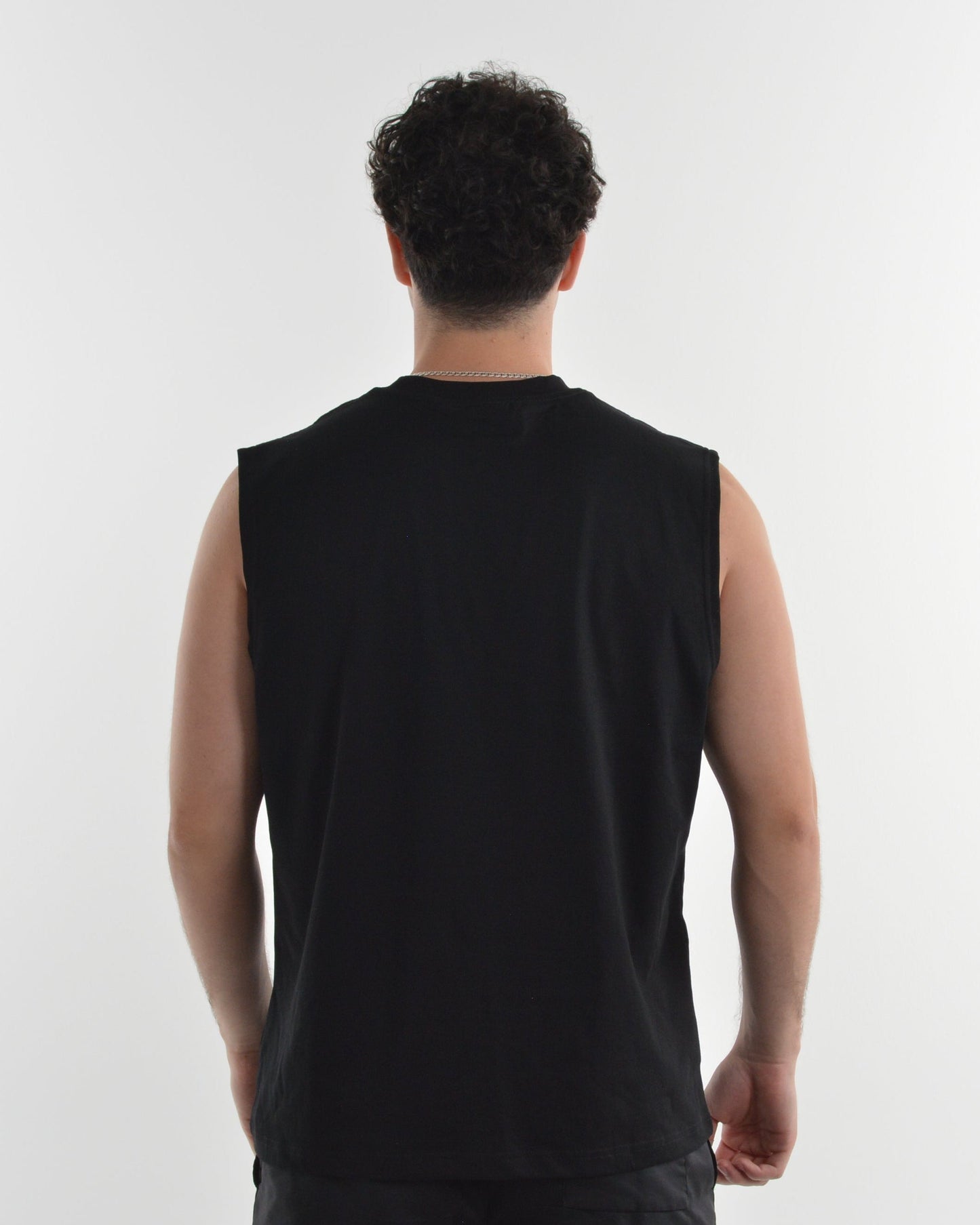 Person wearing a black sleeveless shirt on a white background