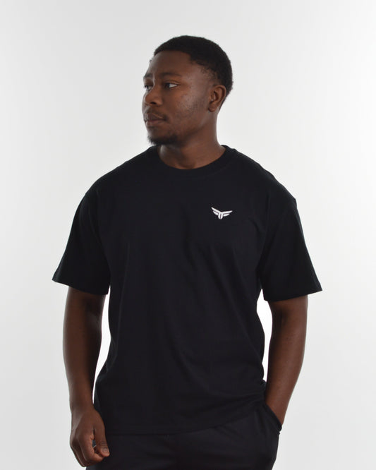 Man wearing a black t-shirt with a white logo on a white background