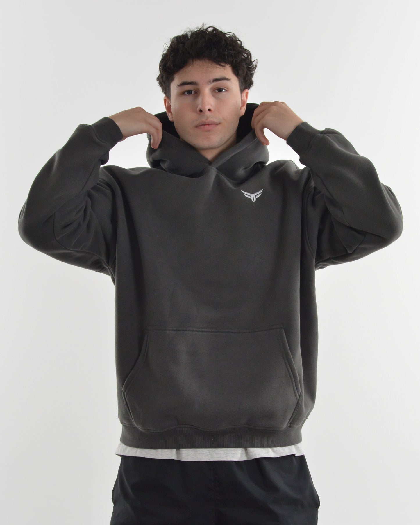 Person wearing a dark gray hoodie on a white background