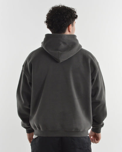 Person wearing a dark gray hoodie and black shorts on a white background