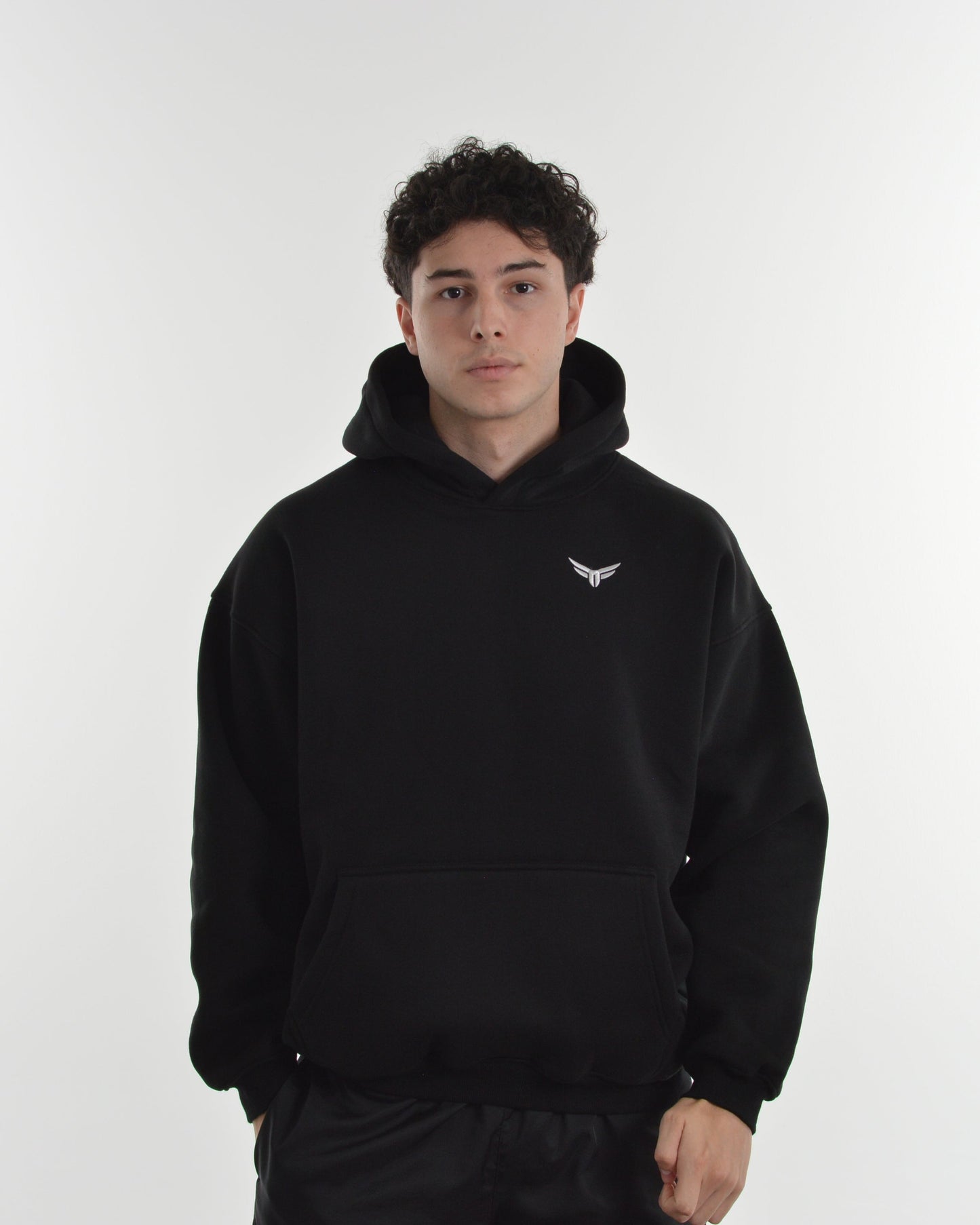 Person wearing a black hoodie with a logo on a white background