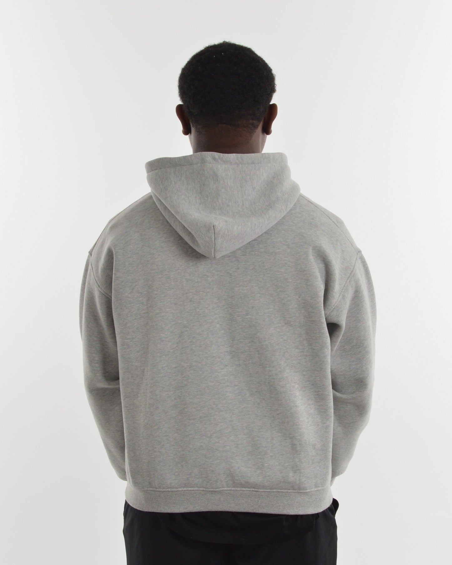 Person wearing a gray hoodie from behind on a white background